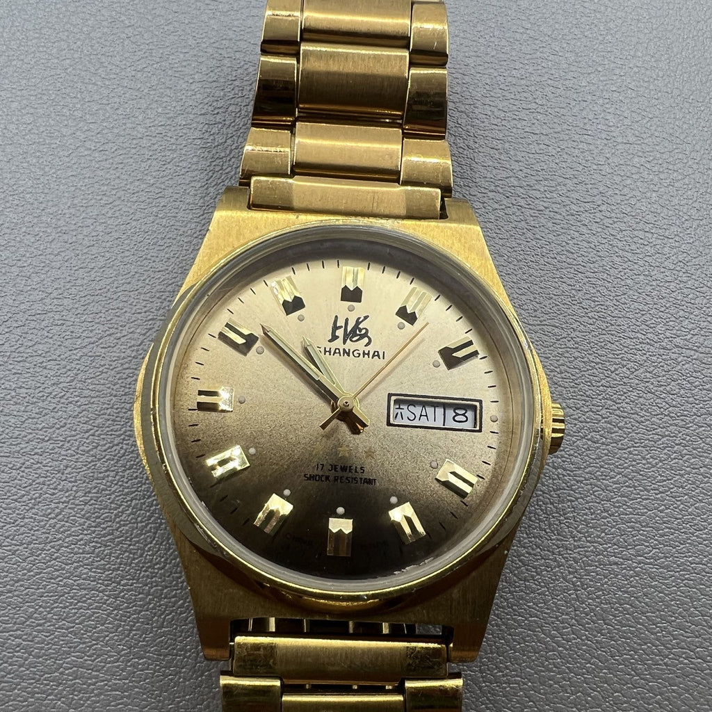 Shanghai Factory manual mechanical watch with dark brown dial and double calendar for elegant timekeeping.