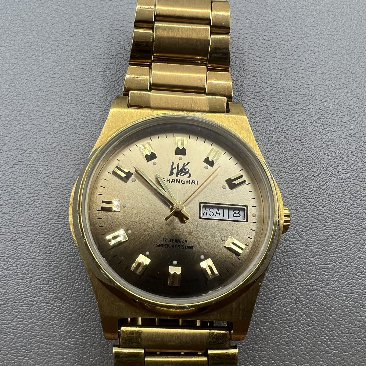Shanghai Factory manual mechanical watch with dark brown dial and double calendar for elegant timekeeping.
