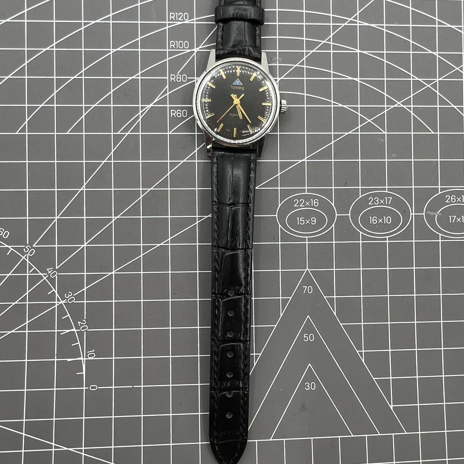 Taihang 32mm manual watch with black dial, golden nail markers, 17 jewels for precise timekeeping.