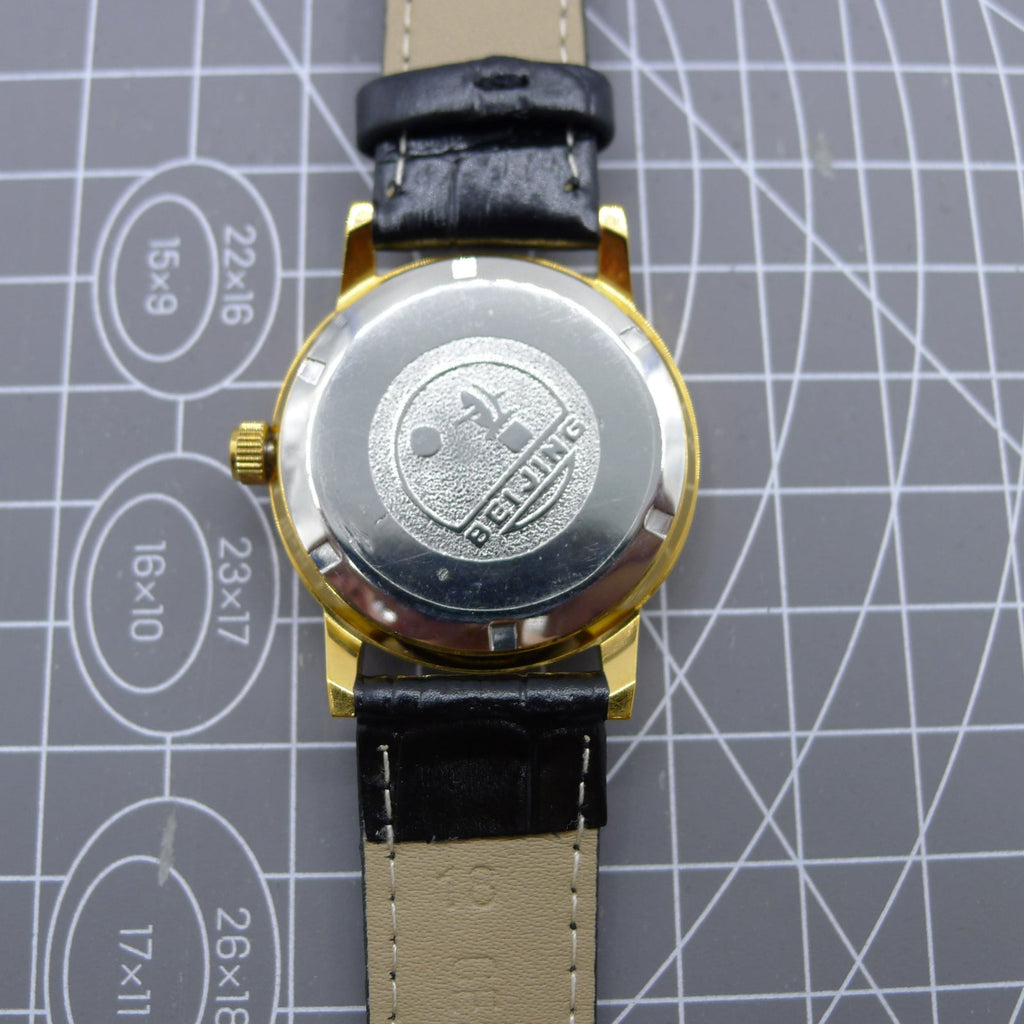 Beijing Double Rhomb mechanical watch with golden case, silver markers, and elegant classic design for formal wear.