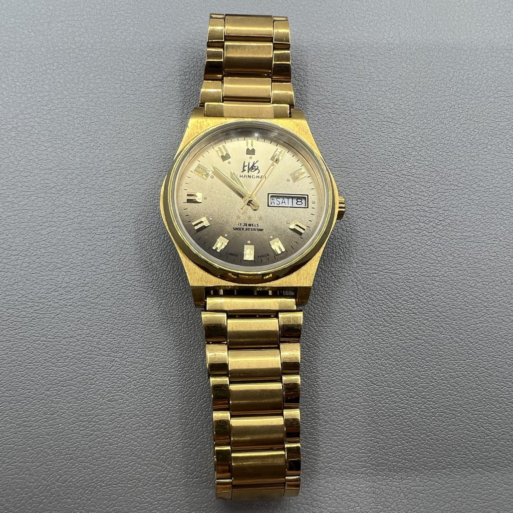 Shanghai Factory manual mechanical watch with dark brown dial and double calendar for precise timekeeping.