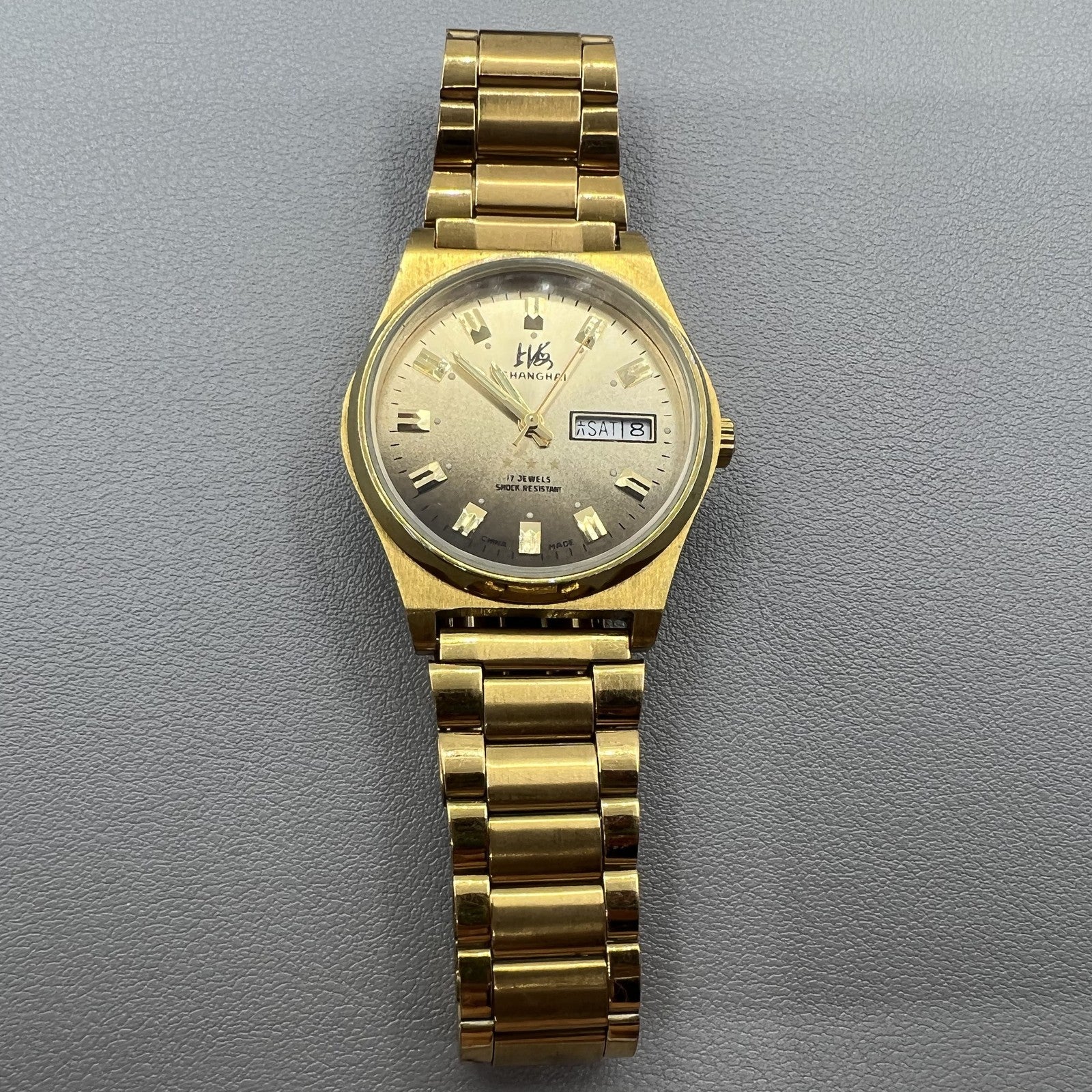 Shanghai Factory manual mechanical watch with dark brown dial and double calendar for precise timekeeping.