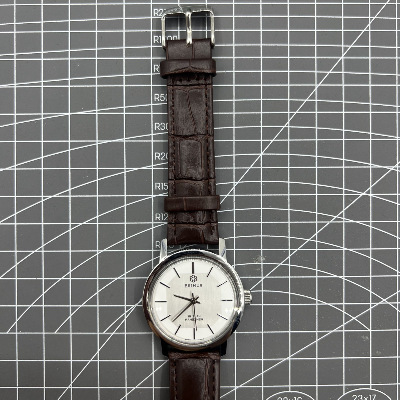 China Baihua 37mm manual mechanical watch with silver dial, 19 jewels, and shock-resistant design.