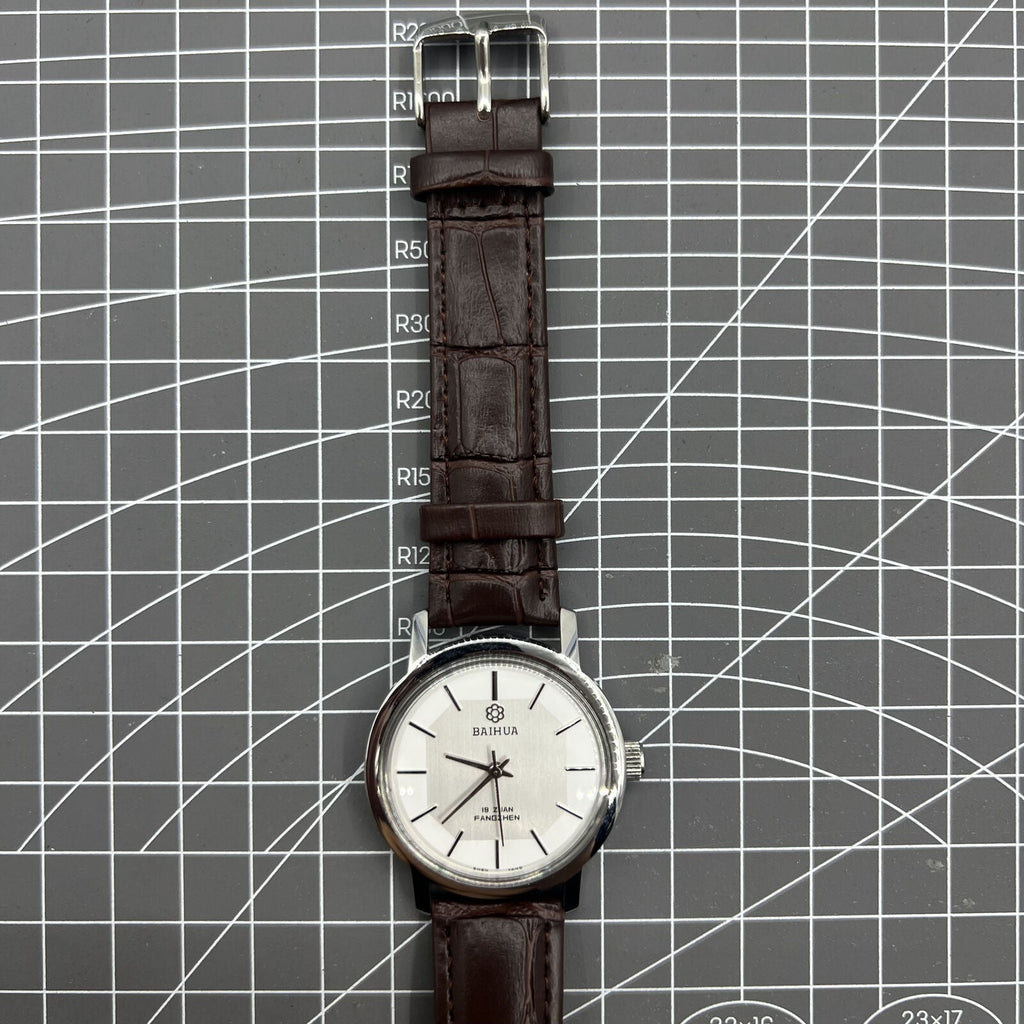 China Baihua 37mm manual mechanical watch with silver dial, 19 jewels, and shock-resistant design.