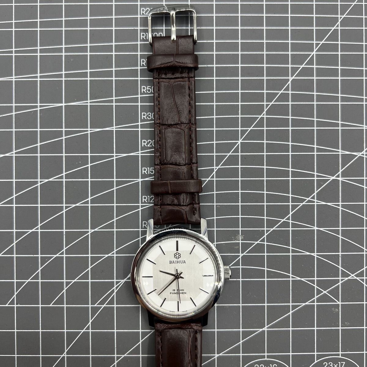 China Baihua 37mm manual mechanical watch with silver dial, 19 jewels, and shock-resistant design.
