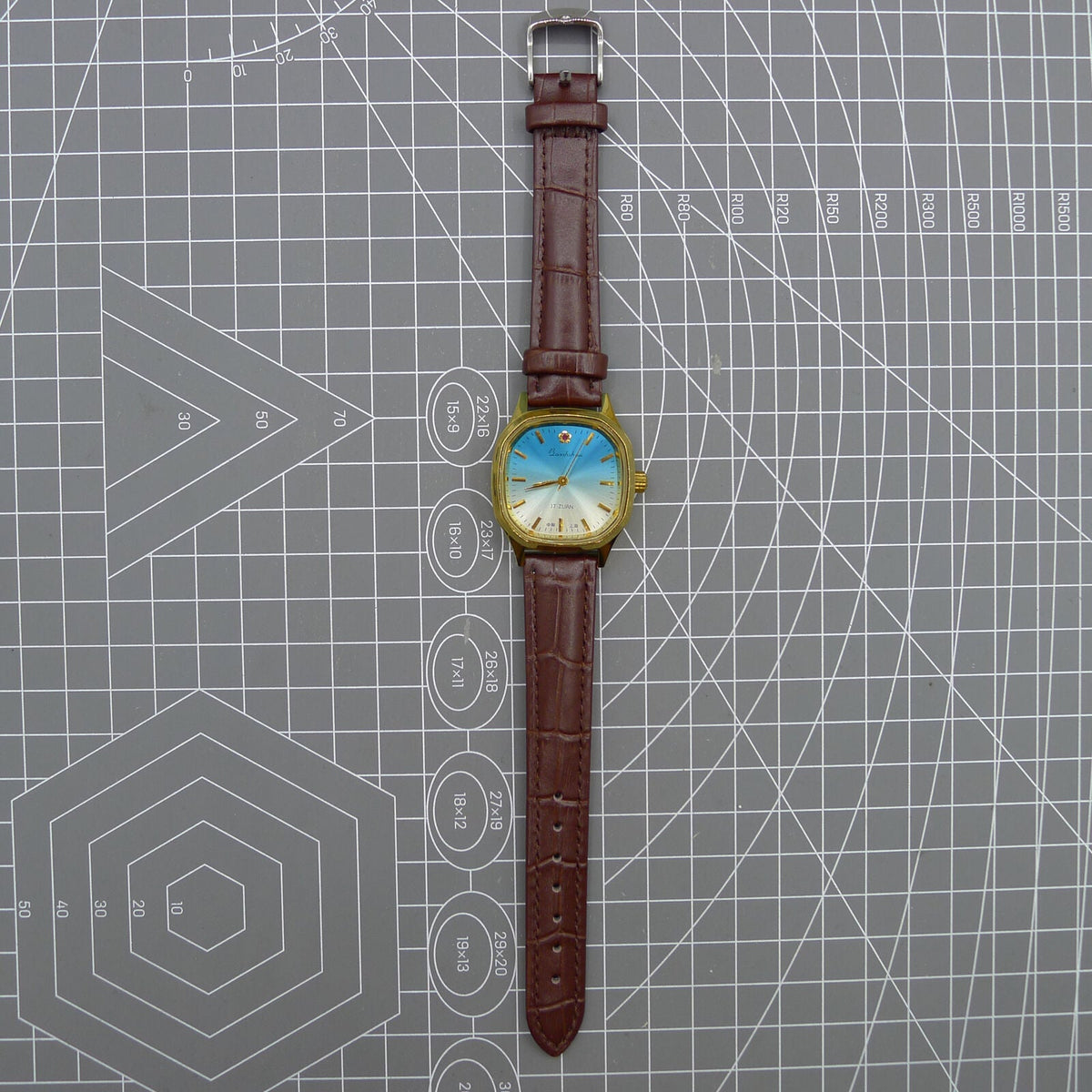 33mm Shanghai watch with blue dial, golden nail markers, square case, manual mechanical movement, 17 jewels.