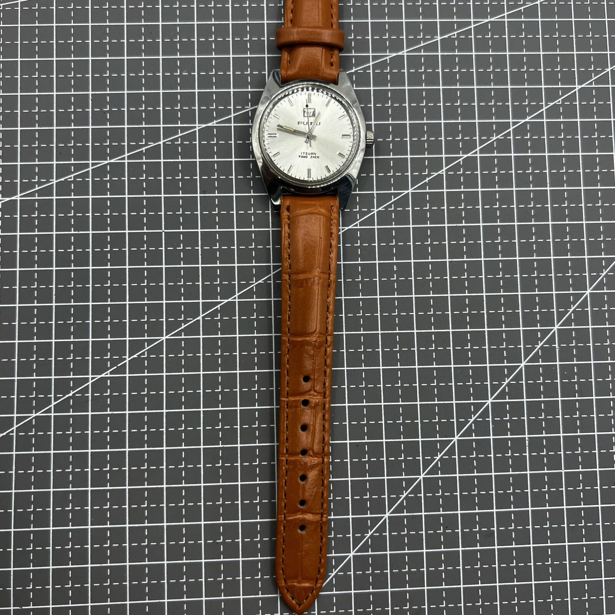 PUBU 32mm manual mechanical watch with grey dial, nail markers, and 17 jewels for precise timekeeping.