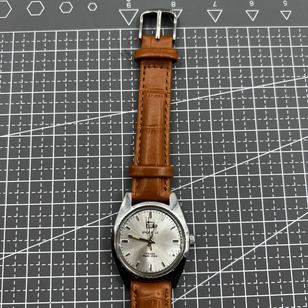 PUBU 32mm manual mechanical watch with grey dial and nail markers, 17 jewels, precision craftsmanship.