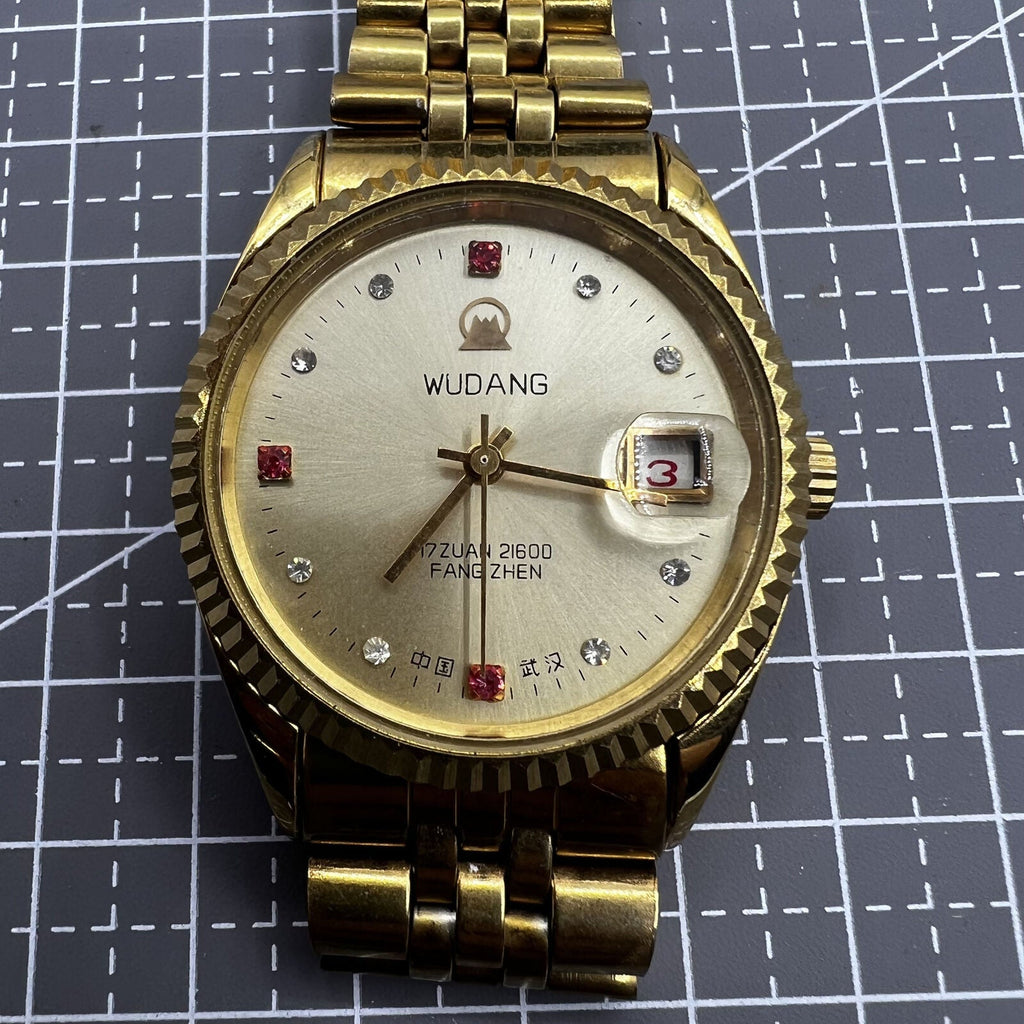 38mm Wudang Steel mechanical watch with golden dial and single calendar, 17 jewels, elegant design.