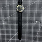 Taihang 32mm manual watch with black strap, gold markers, and black dial for classic elegance.