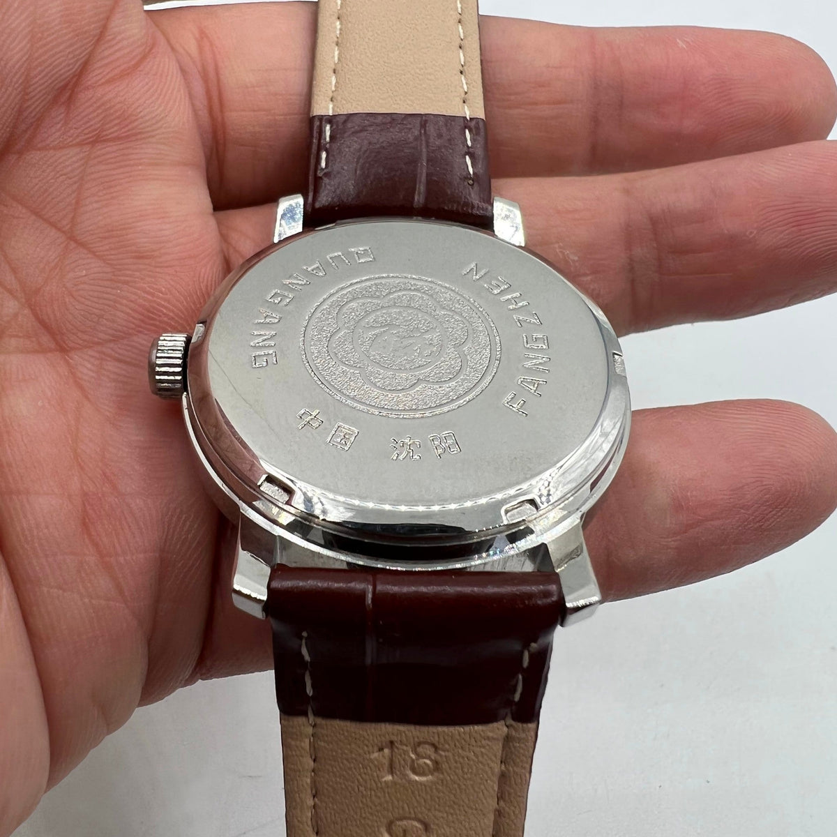 China Baihua 37mm manual mechanical watch with silver dial, 19 jewels, and shock-resistant feature.