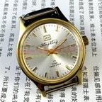 33mm China-made manual mechanical watch with golden hour markers and silver dial, shock-resistant design.