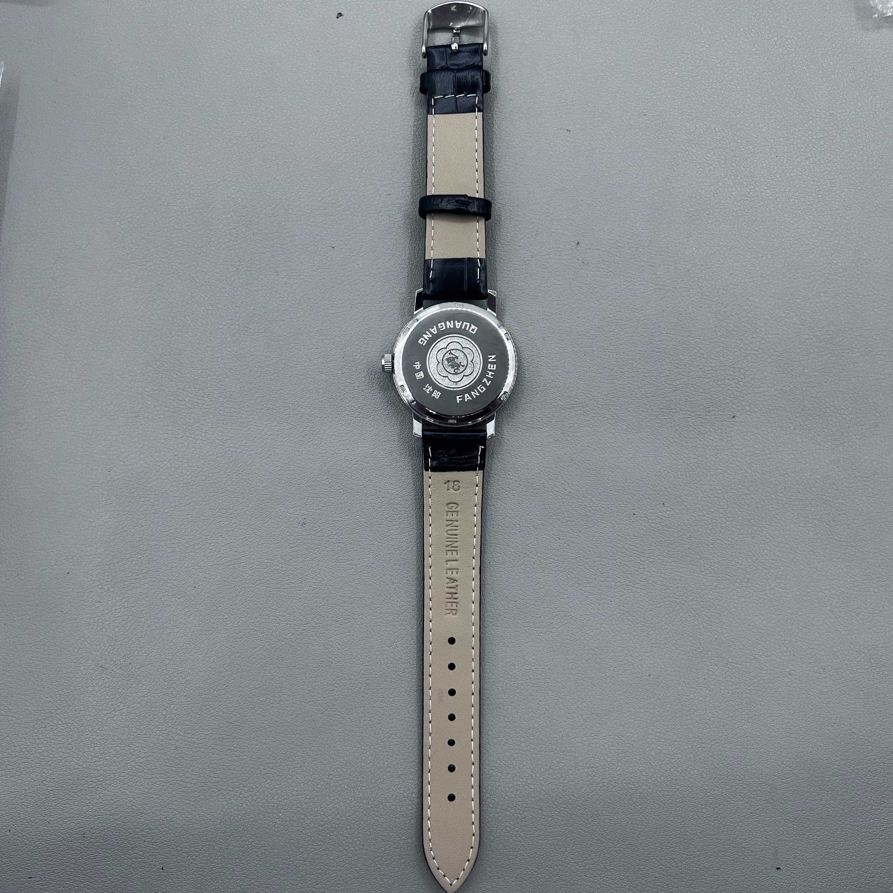 37mm China manual mechanical watch with black strap, silver dial, 19 jewels, shock-resistant design.