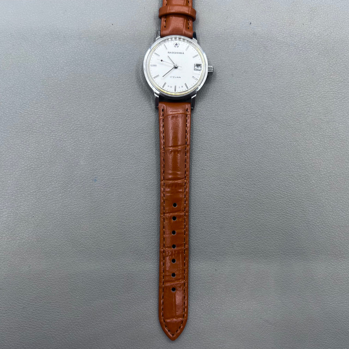 Light brown Shanghai manual mechanical watch with single calendar, 17 jewels, shock-resistant design for durability.