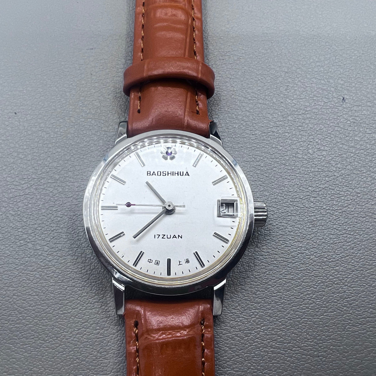 Light brown Shanghai manual mechanical watch with single calendar, 17 jewels, shock-resistant design for durability.