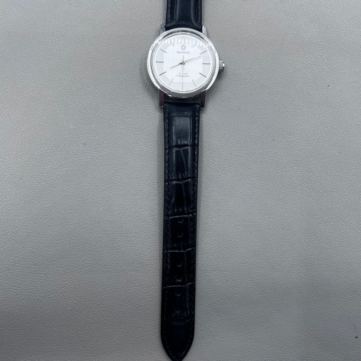 37mm China manual mechanical watch with black strap, silver dial, 19 jewels, shock-resistant design.