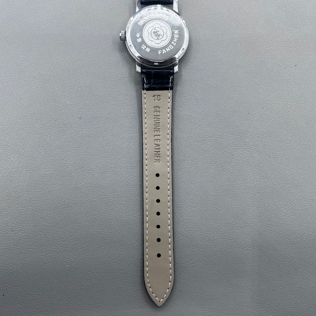 37mm China manual mechanical watch with black strap, silver dial, 19 jewels, shock-resistant design.