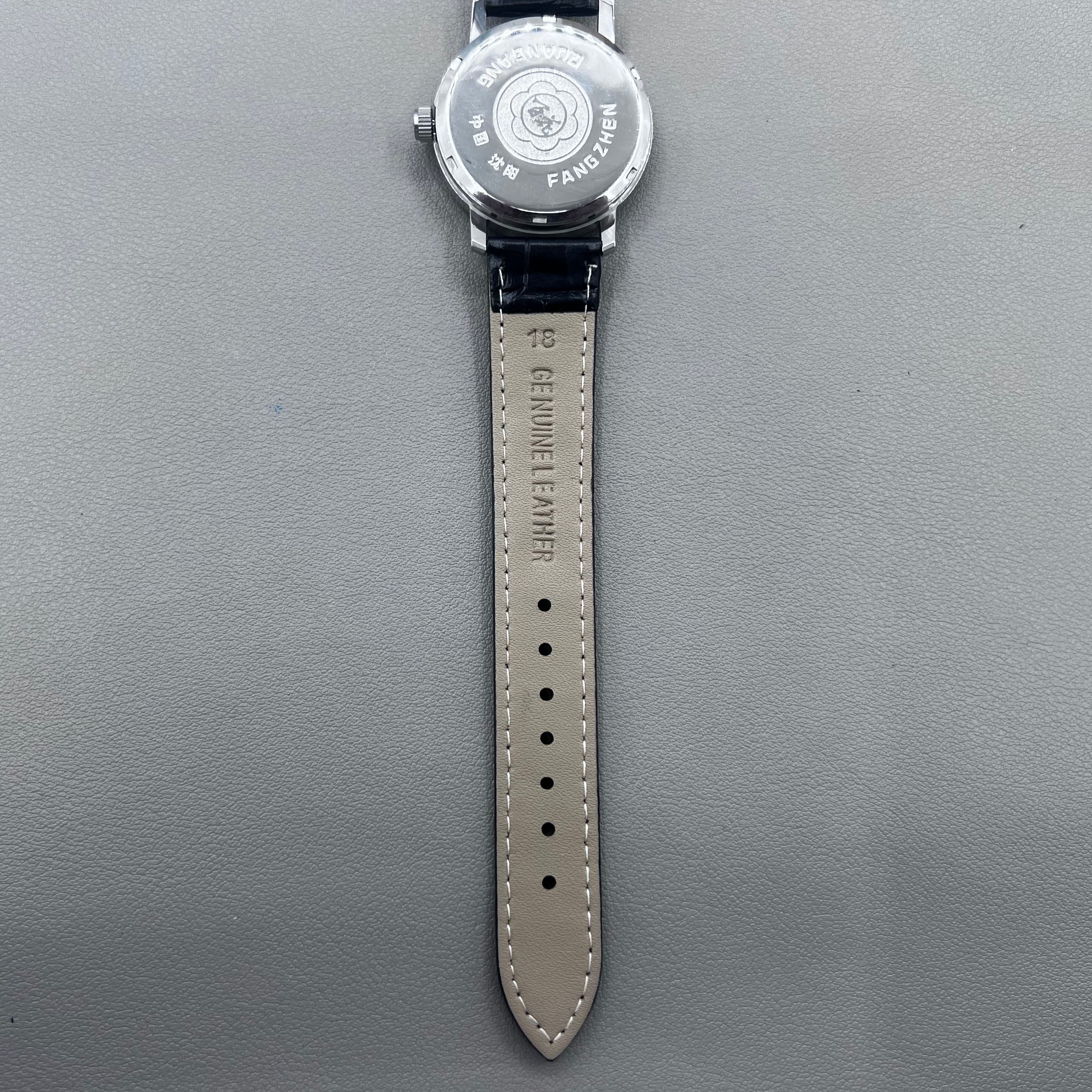 37mm China manual mechanical watch with black strap, silver dial, 19 jewels, shock-resistant design.